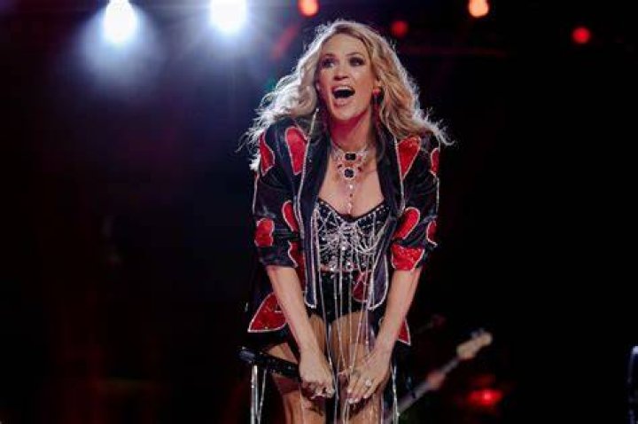 Carrie Underwood commands attention in ripped mini skirt and metallic boots as she details exciting news