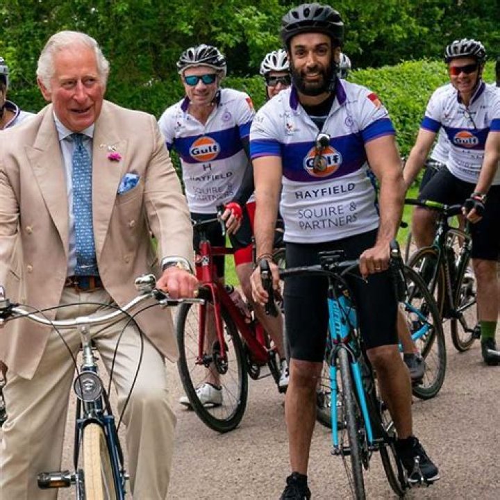 Prince Charles get the giggles as he rides a bicycle near his country home - watch video