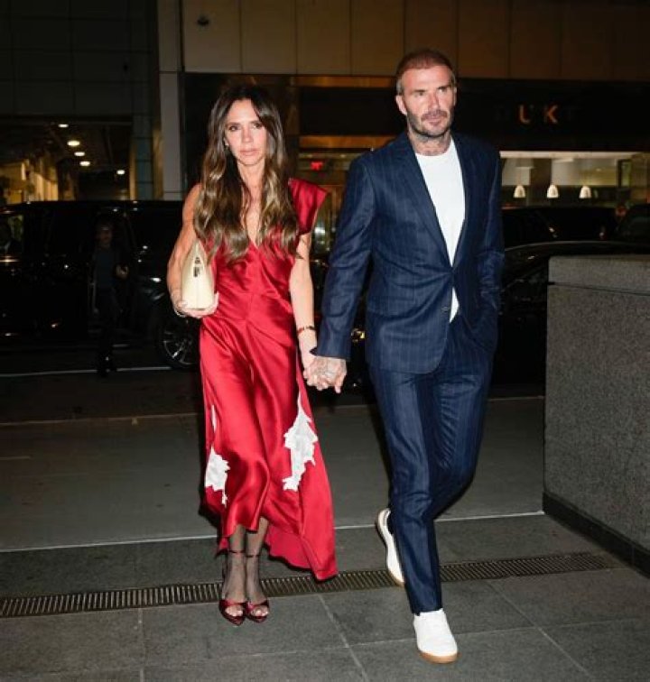Victoria Beckham stuns in slinky satin dress and fishnet tights
